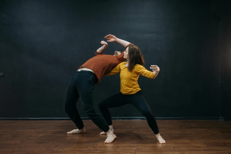 a couple of people standing on top of a wooden floor, by Arabella Rankin, unsplash, arabesque, fighting with angles, on grey background, background image, performance