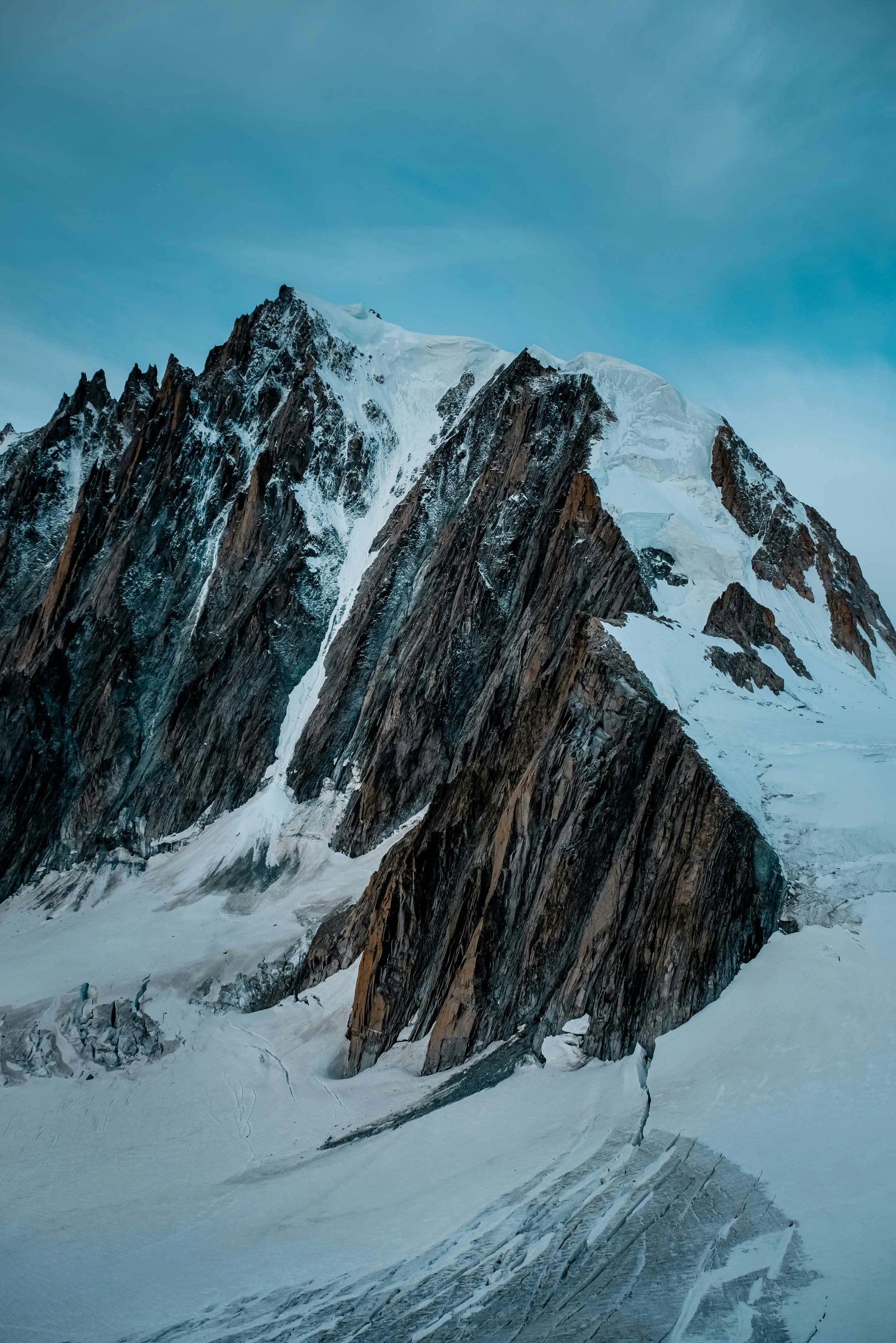 a person standing on top of a snow covered mountain, by Sven Erixson, pexels contest winner, les nabis, “ aerial view of a mountain, rocky cliffs, chamonix, high resolution photo