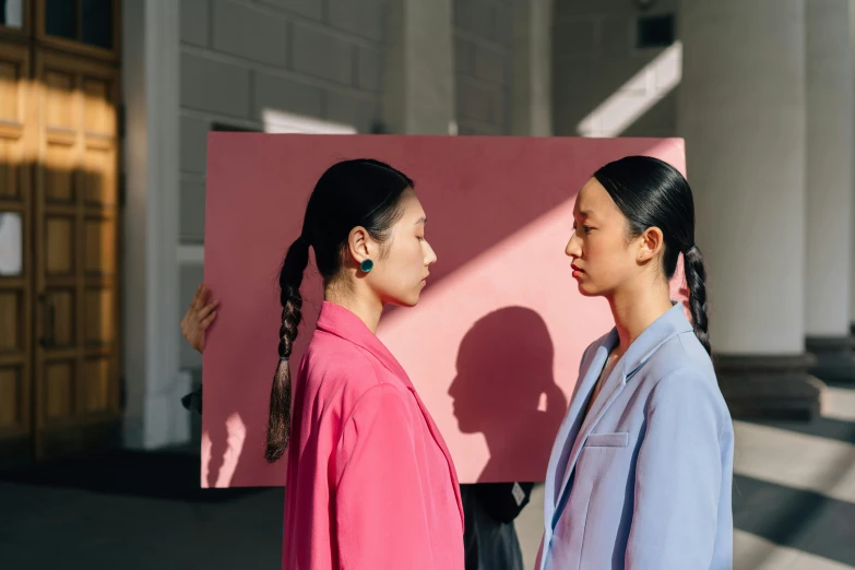 a couple of women standing next to each other, inspired by Wang Duo, pexels contest winner, hyperrealism, colour blocking, giant earrings, asian human, pink shadows