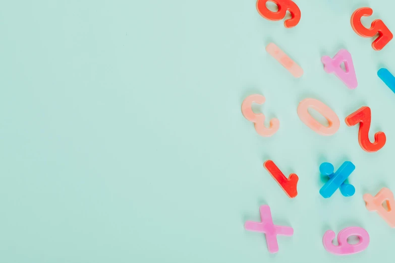 a close up of letters and numbers on a blue surface, trending on pexels, turquoise pink and green, x, floating objects, background image