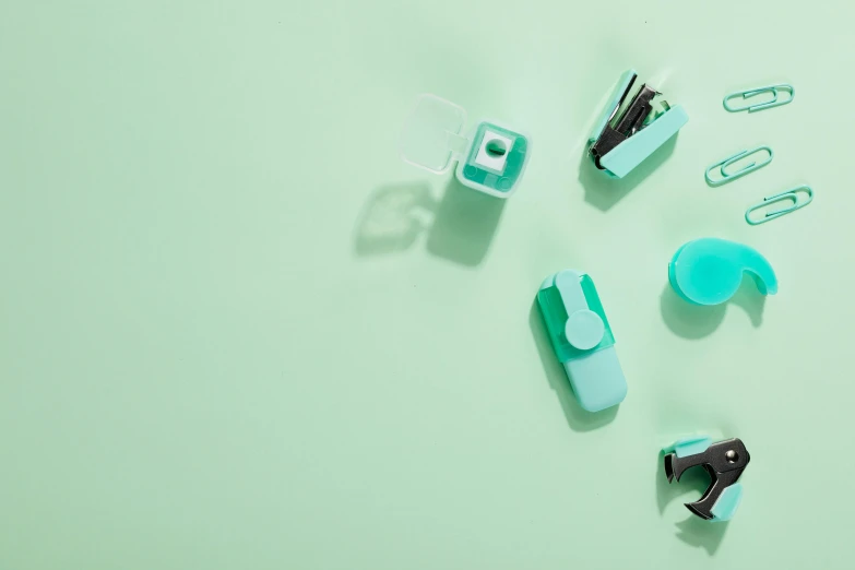 a group of office supplies sitting on top of a green surface, seafoam green, ((greenish blue tones)), skincare, zippers