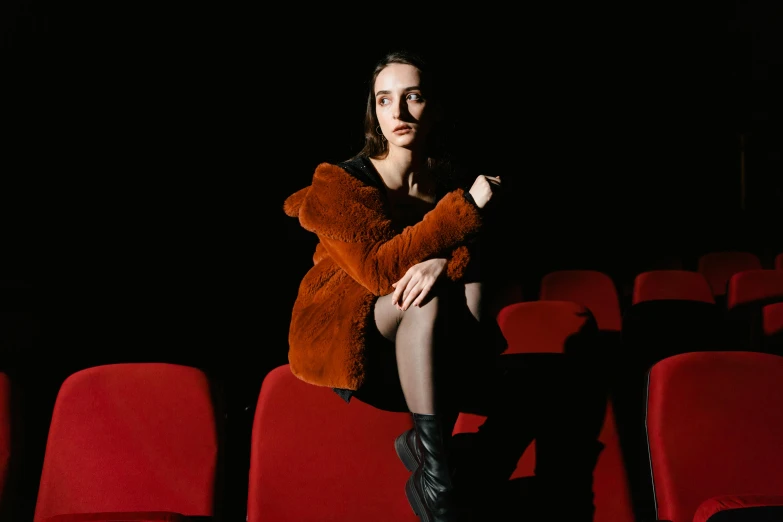 a woman sitting in a theater holding a teddy bear, pexels contest winner, antipodeans, ana de armas portrait, suspiria, sitting on chair, 35mm picture