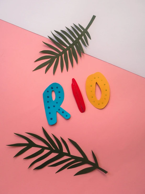 the word rio spelled in felt letters on a pink and white background, an album cover, by Rachel Reckitt, red and teal and yellow, palms, spots, made out of clay