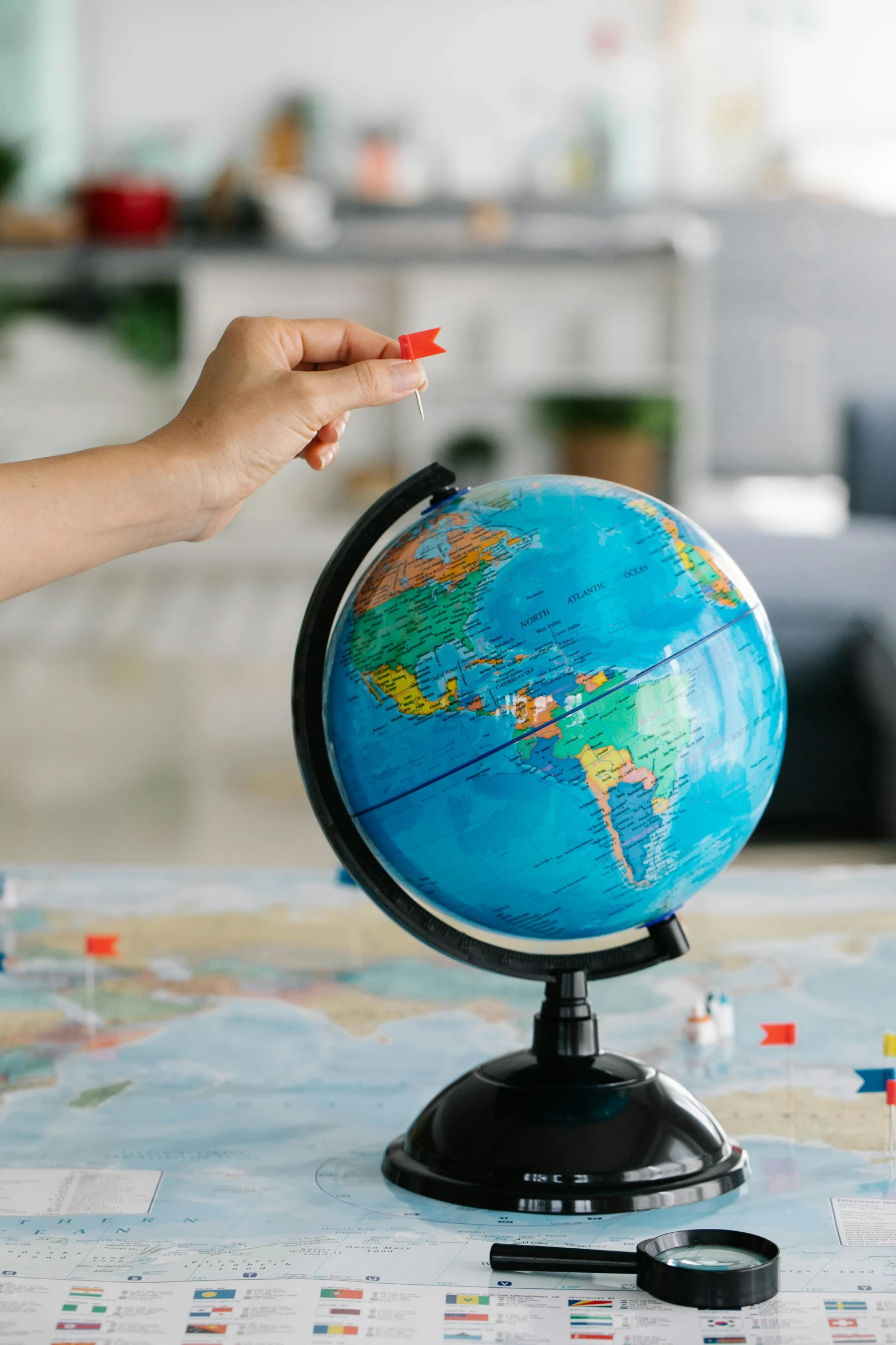 a person pointing at a globe on a table, model kit, thumbnail, round-cropped, most popular