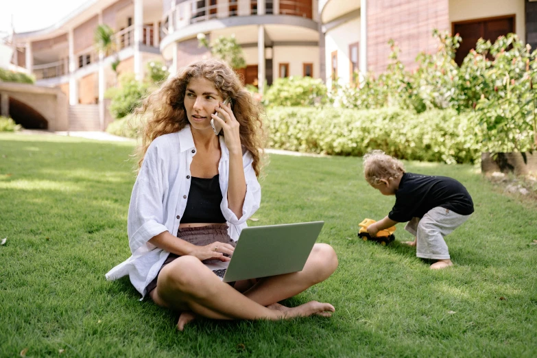 a woman sitting on the grass talking on a cell phone, future coder looking on, sitting at a computer, little kid, at college