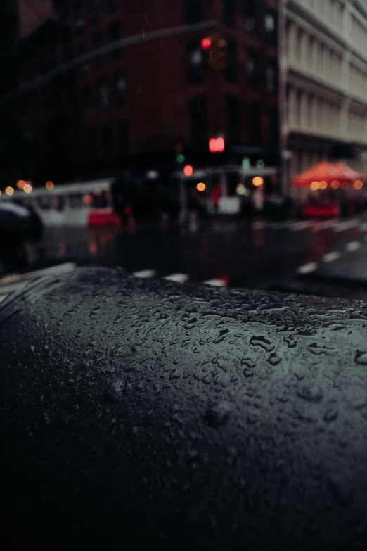 a wet windshield of a car on a city street, by Andrew Domachowski, unsplash contest winner, photorealism, chilly dark mood, background image, streets of new york, grainy footage