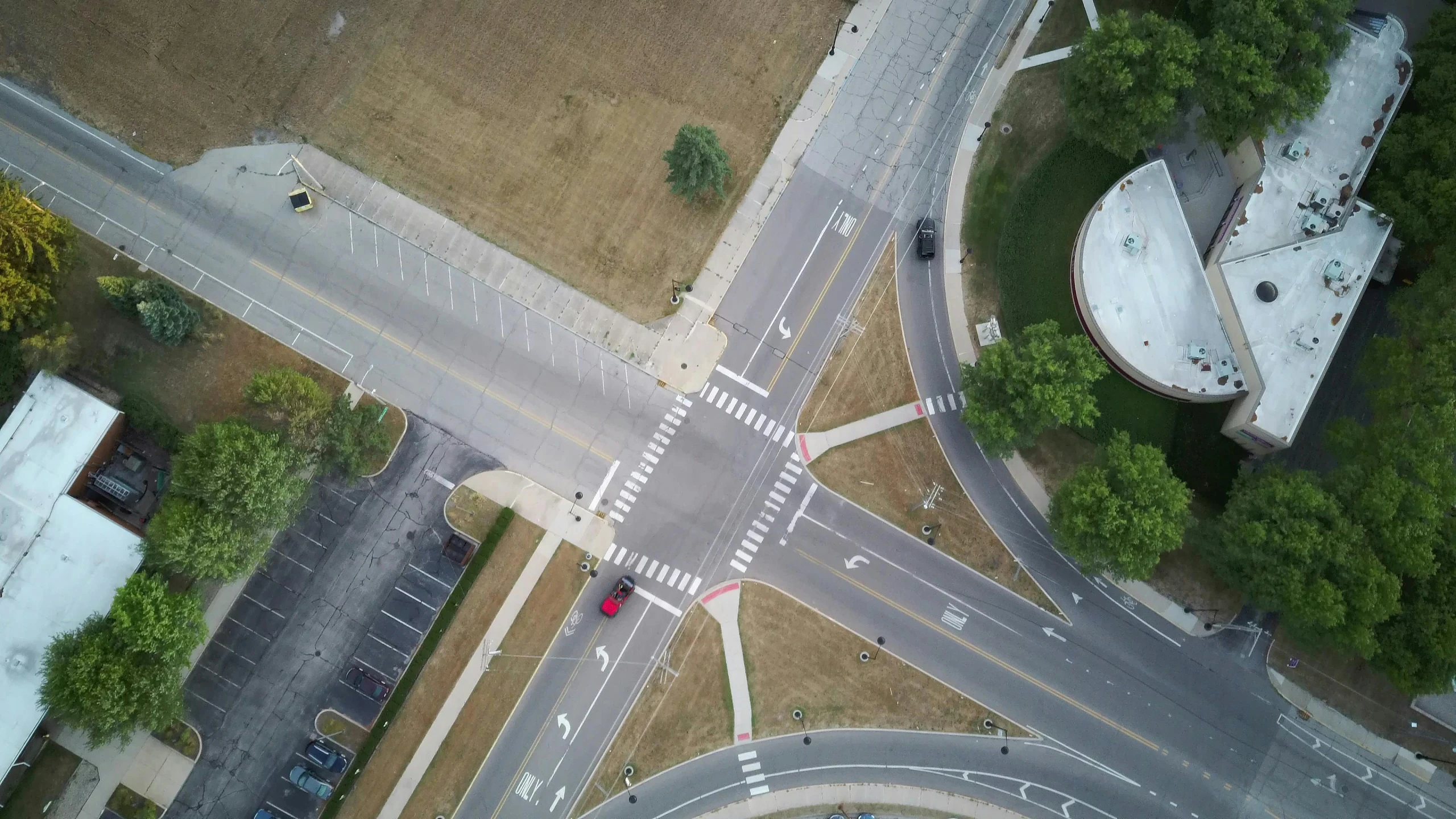 an aerial view of an intersection in a city, by Josh Bayer, unsplash contest winner, photorealism, square, from wheaton illinois, taken on a 2010s camera, drone footage