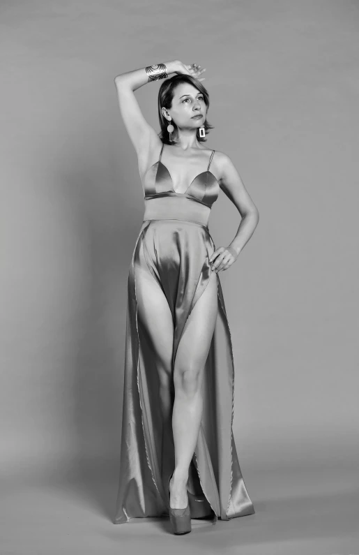 a black and white photo of a woman in a dress, an album cover, inspired by Horst Antes, reddit, wearing silver silk robe, wearing two - piece swimsuit, cindy avelino, carice van houten