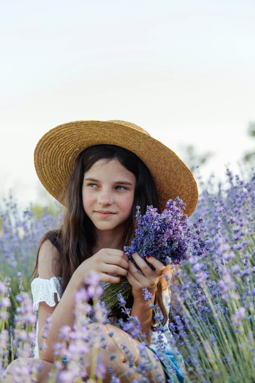 a girl in a hat sitting in a field of lavender, pexels contest winner, kids, girl with dark brown hair, avatar image, product introduction photo