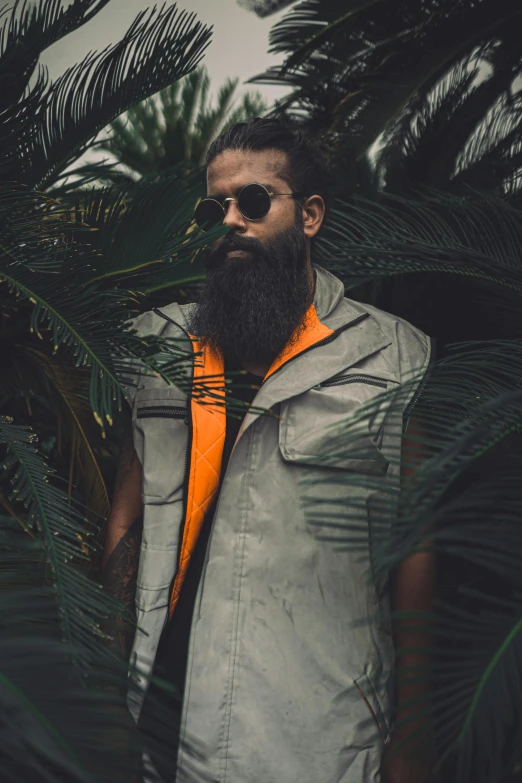 a man with a beard wearing an orange tie, an album cover, by Byron Galvez, pexels contest winner, model is wearing techtical vest, tropical trees, dark shades, overalls and a white beard