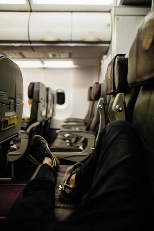 a person sitting in an airplane with their feet up, airplanes, less detailing, evenly lit, slightly minimal