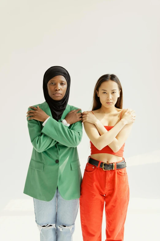 a couple of women standing next to each other, mix of ethnicities and genders, green clothing, promo photo, concern