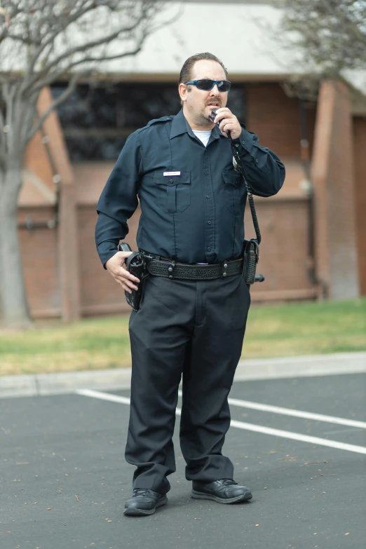 a man standing in a parking lot talking on a cell phone, officers uniform, promo image, idaho, wide full body