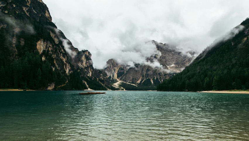 a body of water with mountains in the background, inspired by Thomas Struth, pexels contest winner, dolomites, while it's raining, conde nast traveler photo, corinne day