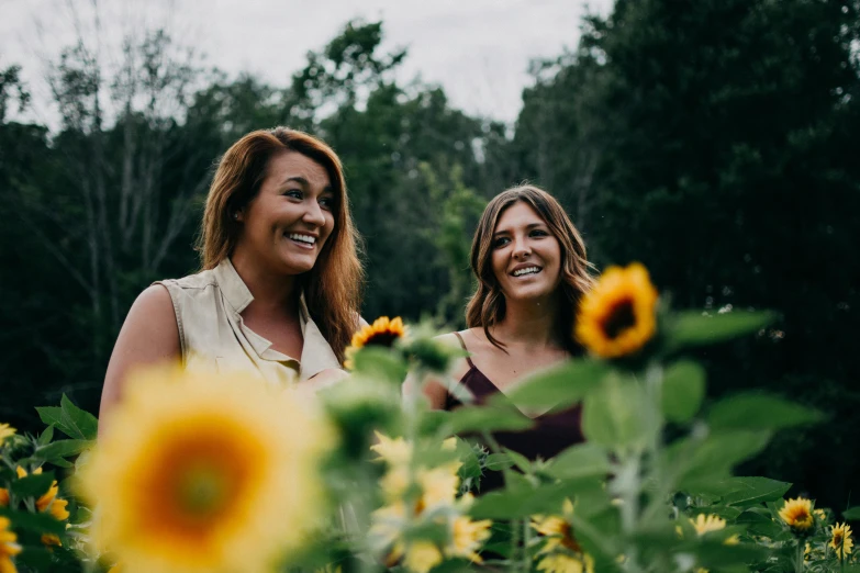 a couple of women standing next to each other in a field of sunflowers, a portrait, by Carey Morris, pexels contest winner, in a cottagecore flower garden, both laughing, avatar image, shallow depth of fielf