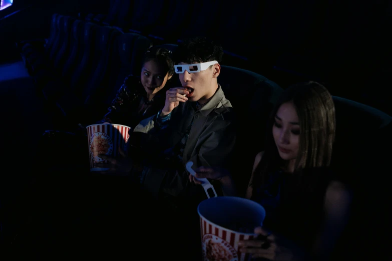 a group of people sitting in a movie theater, a hologram, pexels, hyperrealism, yanjun chengt, popcorn as morpheus, at night, slide show