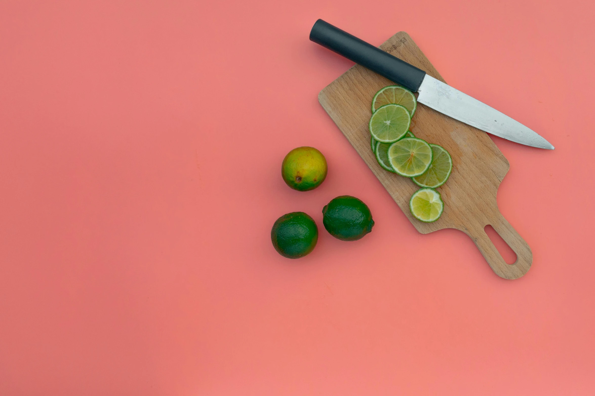 a cutting board with limes and a knife on it, by Carey Morris, pexels contest winner, orange background, background image, multiple stories, minimalissimo