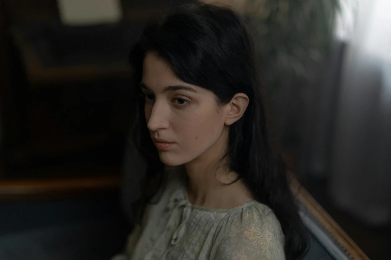 a woman with long black hair sitting in a chair, by Elsa Bleda, pexels contest winner, serial art, in a movie still cinematic, pale-skinned persian girl, head and shoulders view, valentin serov style