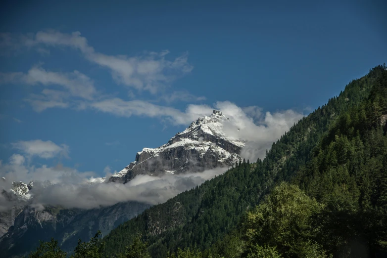 a mountain covered in snow next to a forest, by Peter Churcher, pexels contest winner, hurufiyya, india, avatar image, clear skies, larapi