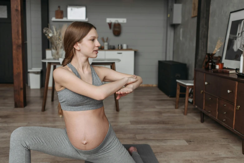 a pregnant woman doing a yoga pose in a living room, pexels contest winner, profile image, coerent face and body, close body shot, cutecore