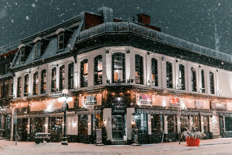 a large building covered in snow next to a street, pexels contest winner, pub, background image, new england architecture, christmas night