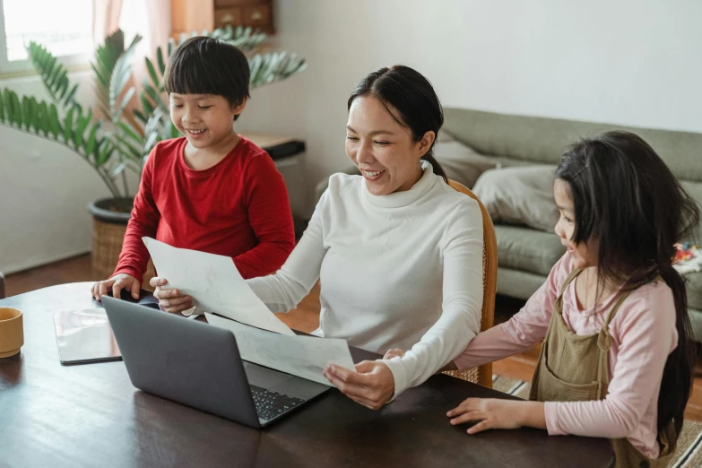 a woman and two children sitting at a table with a laptop, pexels contest winner, japanese collection product, school curriculum expert, te pae, papers on table