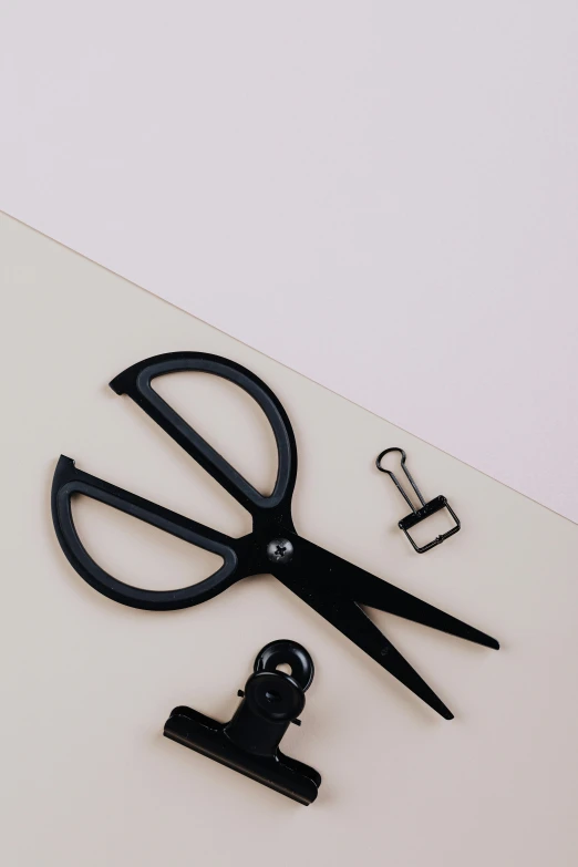 a pair of scissors sitting on top of a piece of paper, all black matte product, extended clip, in kaethe butcher, detail shot