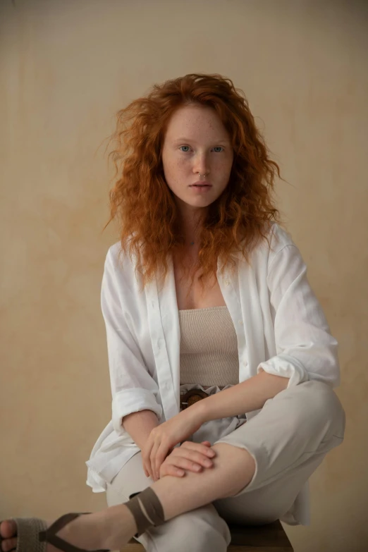 a woman sitting on top of a wooden bench, by Daniel Seghers, trending on pexels, renaissance, curly red hair, wearing a linen shirt, soft studio light, white suit