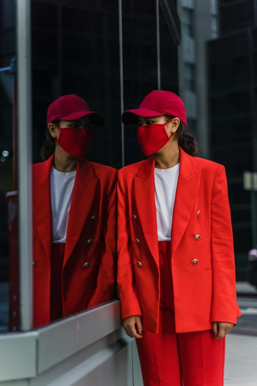 a woman in a red suit and a man in a red mask, an album cover, by Nina Hamnett, pexels contest winner, fashion week, mirrored, unsplash contest winning photo, work clothes