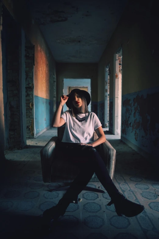 a woman sitting in a chair talking on a cell phone, a polaroid photo, inspired by Elsa Bleda, unsplash contest winner, graffiti, dark hat, portrait of max caulfield, in the middle of an empty room, confident pose