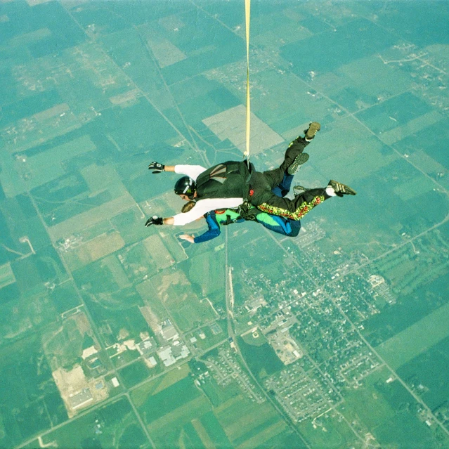 a person that is in the air with a parachute, posing for camera, looking down on the camera