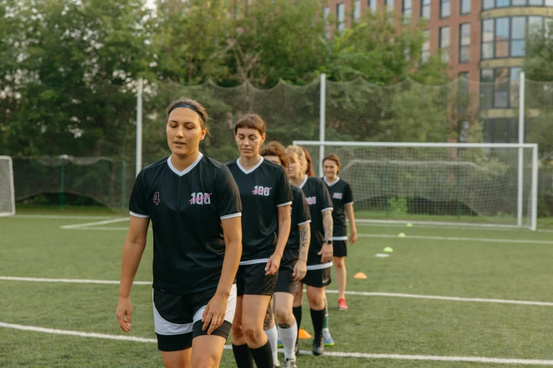 a group of young women standing on top of a soccer field, pexels contest winner, ashcan school, looking to the side off camera, subtitles, attacking nyc, 8k octan photo