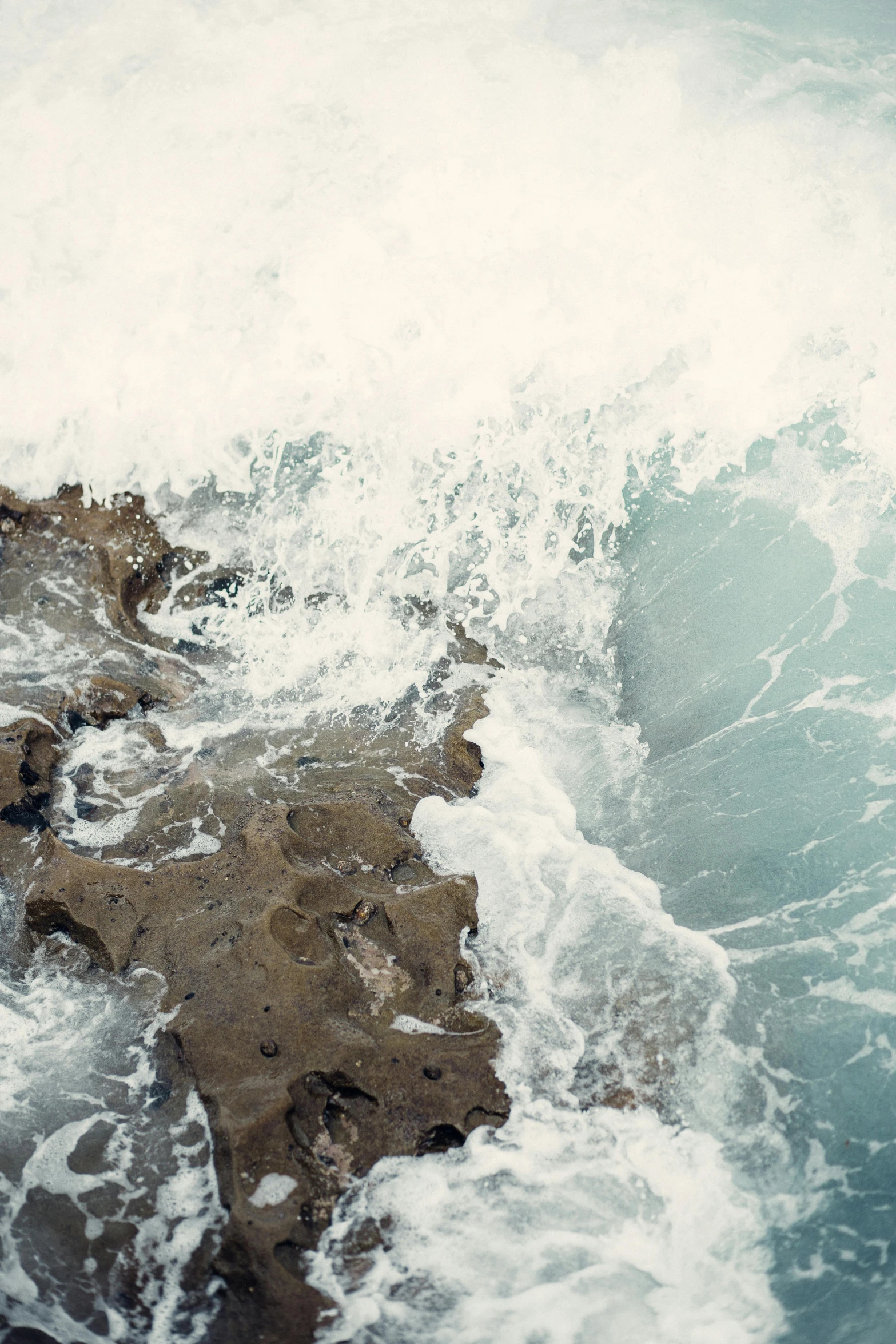 a man riding a wave on top of a surfboard, an album cover, trending on unsplash, renaissance, organic swirling igneous rock, high angle close up shot, sea foam, 4 k cinematic still