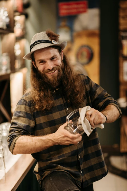 a man sitting at a bar pouring a drink, a portrait, pexels contest winner, renaissance, lumberjack, official store photo, smiling slightly, hand holding cap brim