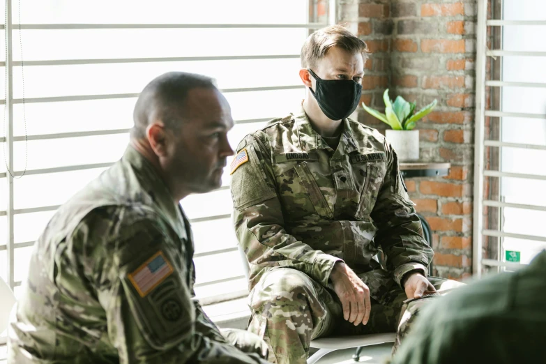 a couple of men sitting next to each other, by Everett Warner, pexels, spec - ops head with mask, wearing military uniform, tyler west, patterned