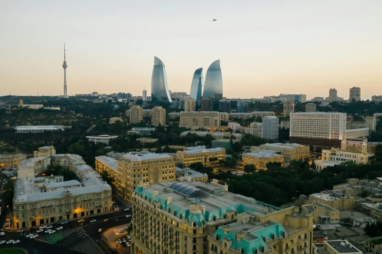 an aerial view of a city at dusk, by Alexander Runciman, pexels contest winner, hurufiyya, ayanamikodon and irakli nadar, zaha hadid building, three views, with stalinist style highrise