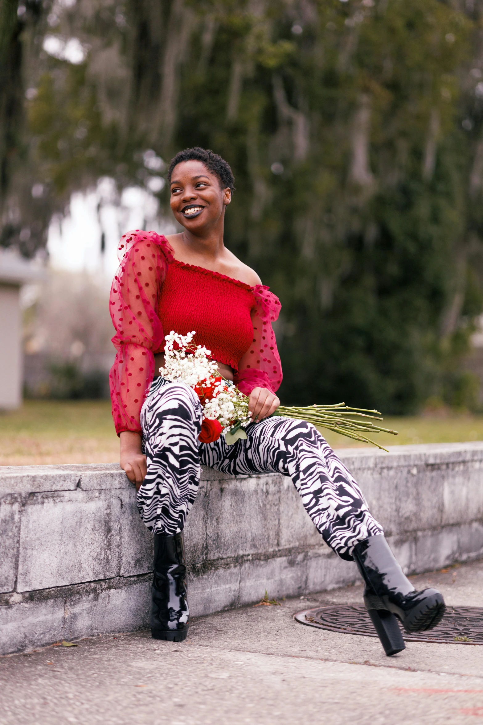 a woman sitting on a wall with a bouquet of flowers, inspired by Winona Nelson, jamel shabazz, in savannah, slide show, crimson themed