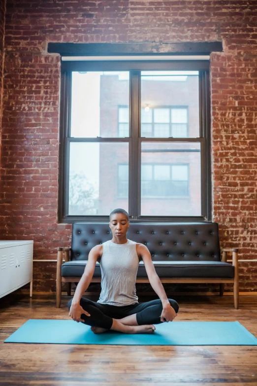 a woman sitting on a yoga mat in front of a window, by Emanuel Witz, pexels contest winner, jemal shabazz, panoramic shot, dwell, centered face shot