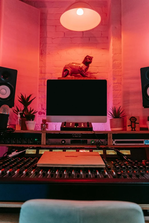 a computer monitor sitting on top of a desk, an album cover, by Adam Rex, trending on pexels, cinema studio lights, pink and red color scheme, in his basement studio, lush lighting