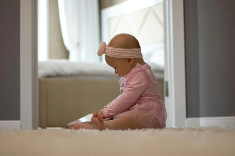 a baby sitting on the floor wearing a headband, by Alice Mason, pexels contest winner, hurufiyya, panels, soft light 4 k in pink, forward facing, album