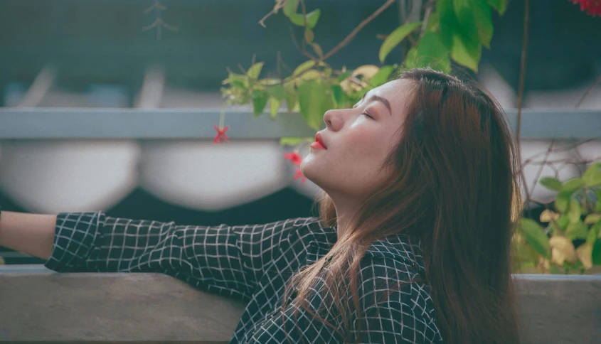 a woman sitting on a bench with her eyes closed, trending on pexels, covered in vines, korean girl, looking upwards, profile image