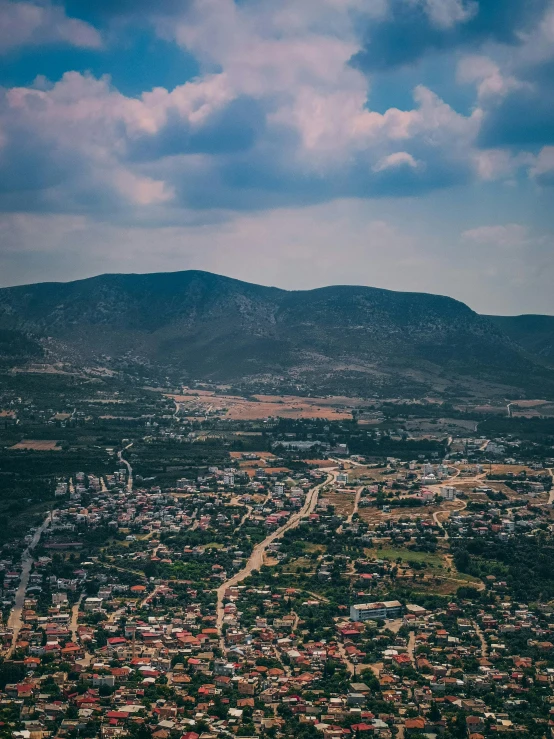 an aerial view of a city with mountains in the background, by Kristian Zahrtmann, pexels contest winner, cyprus, stacked image, multiple stories, slightly pixelated