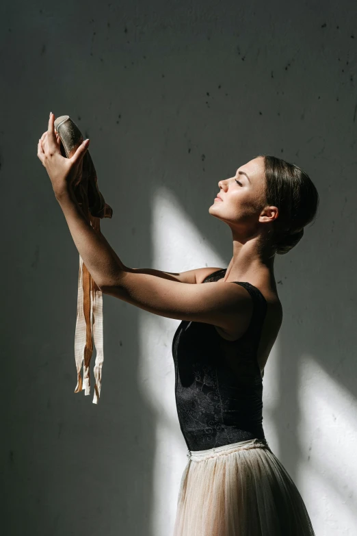 a woman in a black top and a tutu skirt, a picture, by Elizabeth Polunin, unsplash contest winner, arabesque, holding a wood piece, holding a white duck, back light, holding a leather purse