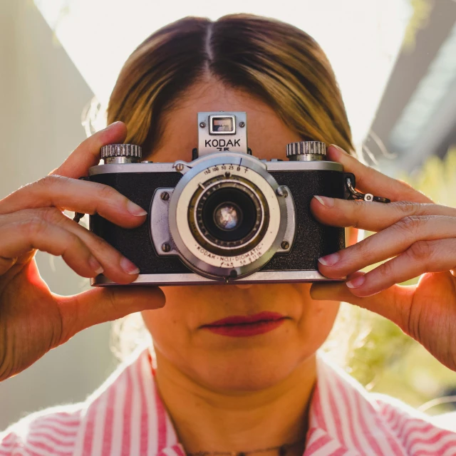 a woman taking a picture with a camera, a picture, inspired by Vivian Maier, pexels contest winner, photorealism, fisheye portrait, vintage color, upper body face shot, fan favorite