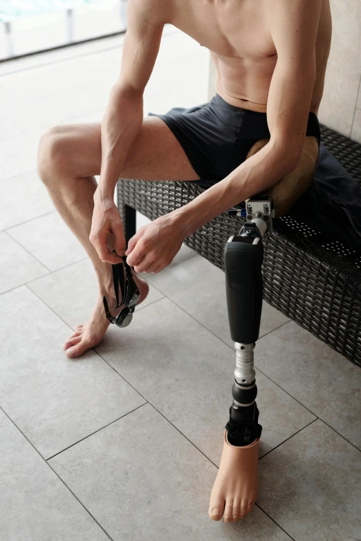 a man with a prosthetic leg sitting on a bench, sitting on the floor, such as arms & legs, splash image, thumbnail