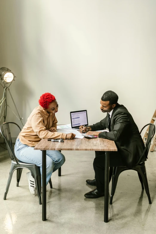 a man and woman sitting at a table with a laptop, selling insurance, riyahd cassiem, no watermarks, ashteroth