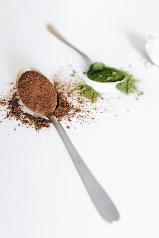 a couple of spoons sitting on top of a table, powder, greens, fully chocolate, detail shot