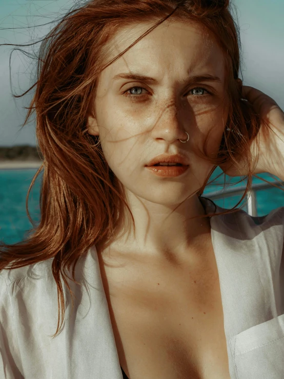 a woman standing in front of a body of water, inspired by Elsa Bleda, trending on pexels, photorealism, brown-red-hair pretty face, ocean eyes, 🤤 girl portrait, clean face and body skin