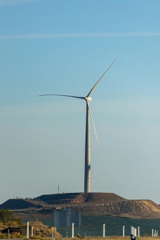 a large wind turbine sitting in the middle of a field, by Joe Stefanelli, january 20th, tall thin, waving, coal