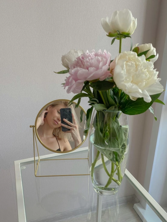 a vase filled with white and pink flowers next to a mirror, a picture, by Anna Boch, instagram contest winner, portrait of kim petras, taken on iphone 14 pro, 🐎🍑, photo of the beauty gal gadot